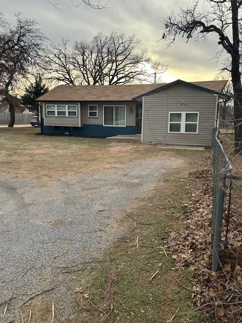 view of front of home with driveway and fence