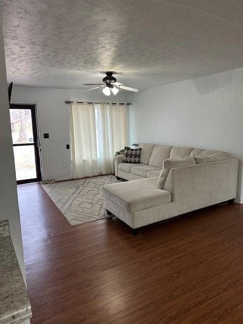 living area with a textured ceiling, wood finished floors, and a ceiling fan