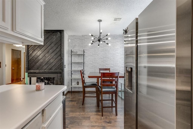 kitchen featuring visible vents, dark wood-style flooring, a textured ceiling, white cabinetry, and stainless steel refrigerator with ice dispenser