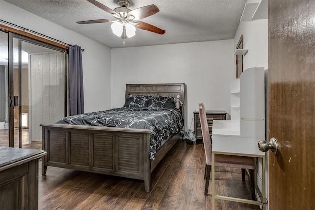 bedroom with dark wood-style floors, a textured ceiling, and a ceiling fan