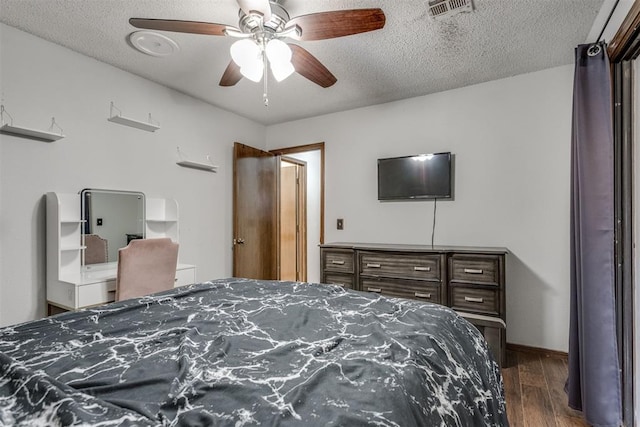 bedroom featuring visible vents, ceiling fan, a textured ceiling, wood finished floors, and baseboards