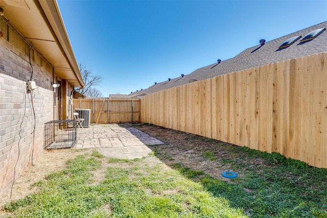 view of yard featuring a patio area, central AC, and a fenced backyard