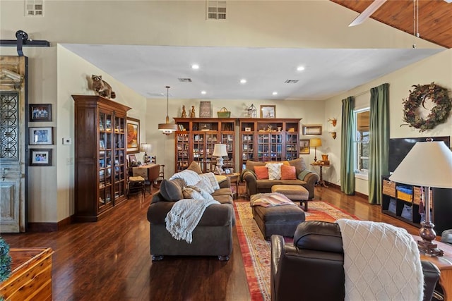 living room with visible vents, a barn door, and dark wood finished floors