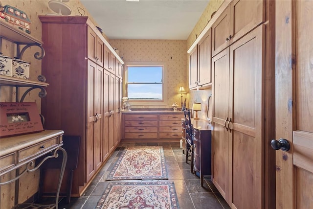 interior space with stone finish flooring and wallpapered walls