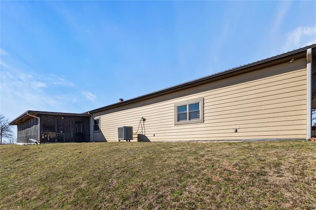 rear view of property featuring a lawn, cooling unit, and a sunroom