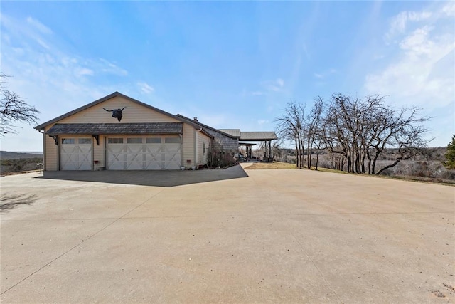 view of property exterior featuring a garage and concrete driveway