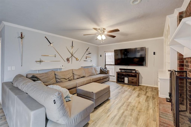 living area with a ceiling fan, baseboards, light wood-style flooring, ornamental molding, and a brick fireplace