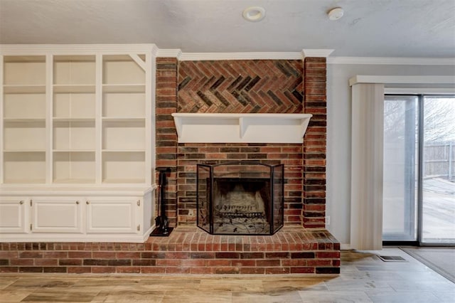 unfurnished living room with a brick fireplace, wood finished floors, baseboards, and ornamental molding