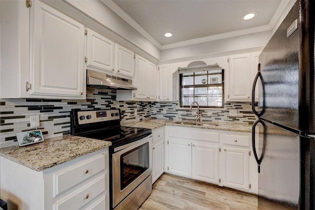 kitchen with under cabinet range hood, stainless steel electric range oven, freestanding refrigerator, white cabinetry, and a sink