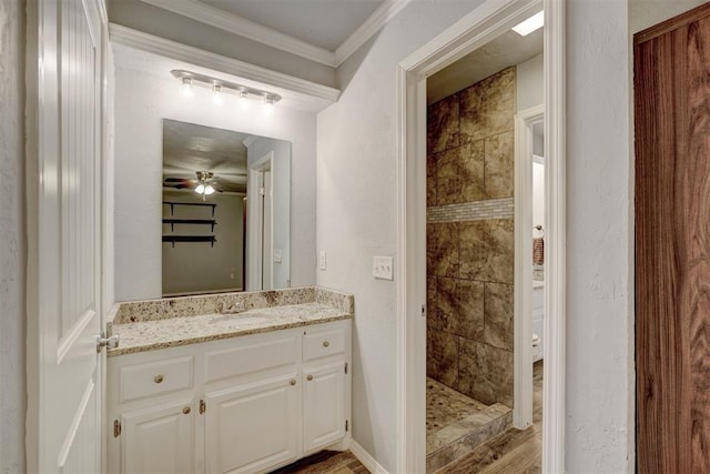 full bath with a textured wall, a ceiling fan, vanity, and crown molding