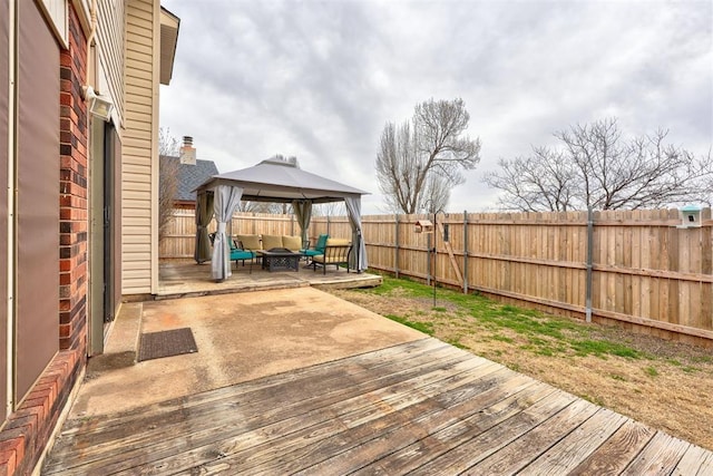 deck featuring a gazebo, a fenced backyard, and a patio