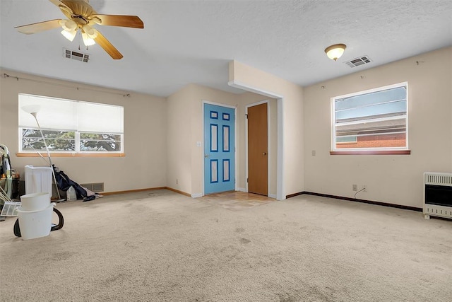 empty room featuring heating unit, visible vents, and carpet flooring