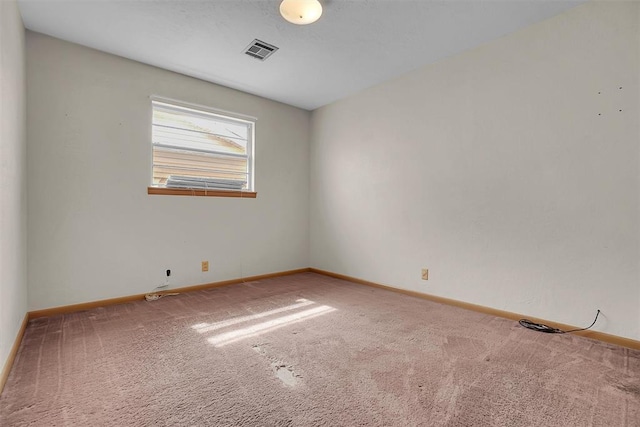 empty room featuring carpet flooring, visible vents, and baseboards