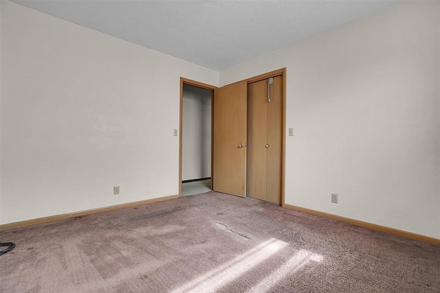 unfurnished bedroom with light carpet and baseboards