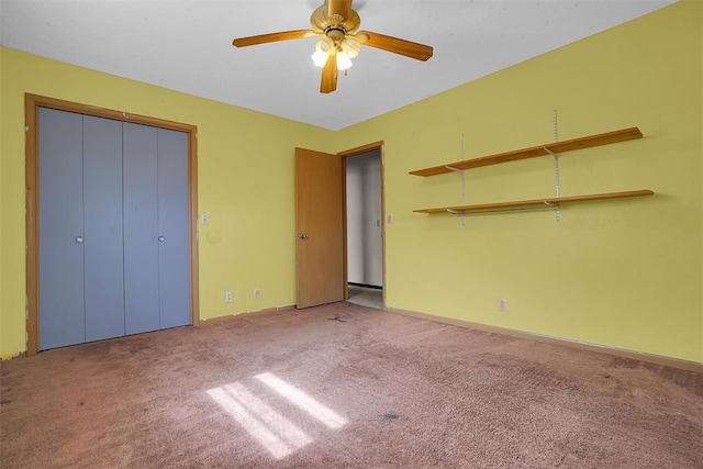 unfurnished bedroom with carpet floors, a closet, baseboards, and a ceiling fan