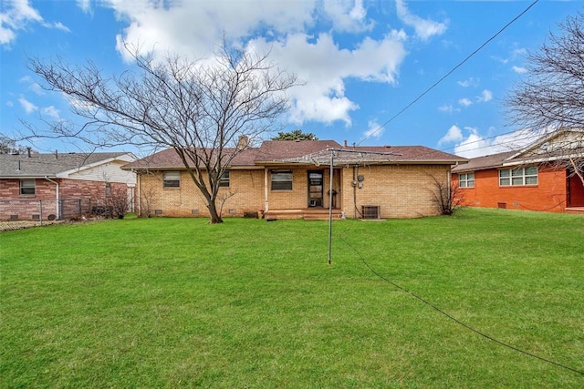 rear view of property featuring a yard, brick siding, and crawl space