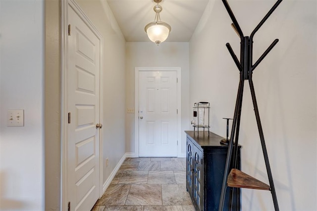 foyer entrance featuring stone finish flooring and baseboards