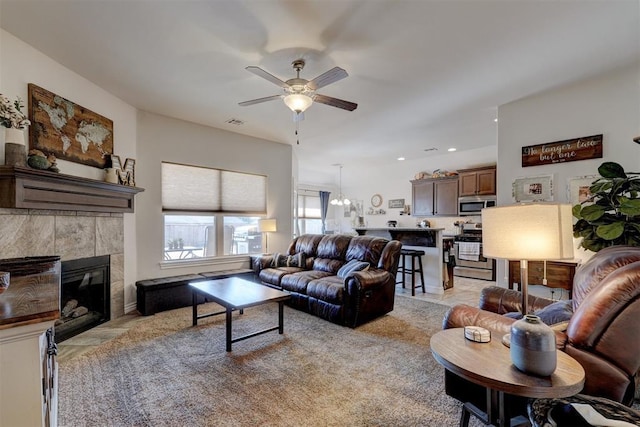 living area featuring a tiled fireplace, recessed lighting, visible vents, and ceiling fan