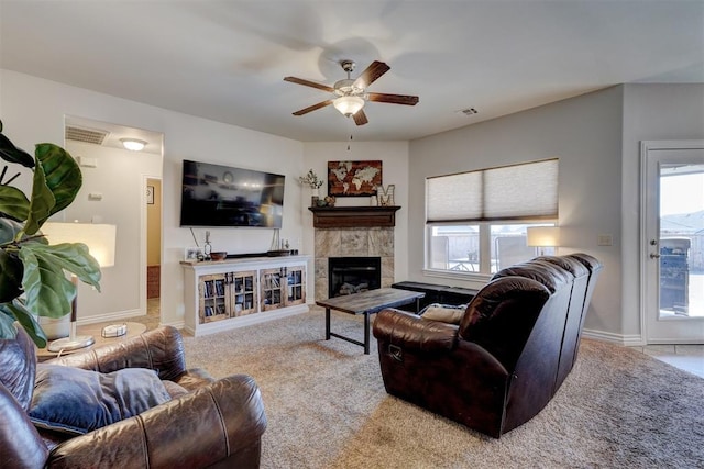 carpeted living room with visible vents, baseboards, ceiling fan, and a fireplace