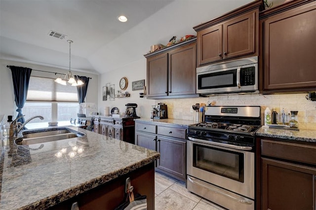 kitchen with visible vents, a sink, backsplash, appliances with stainless steel finishes, and light stone countertops