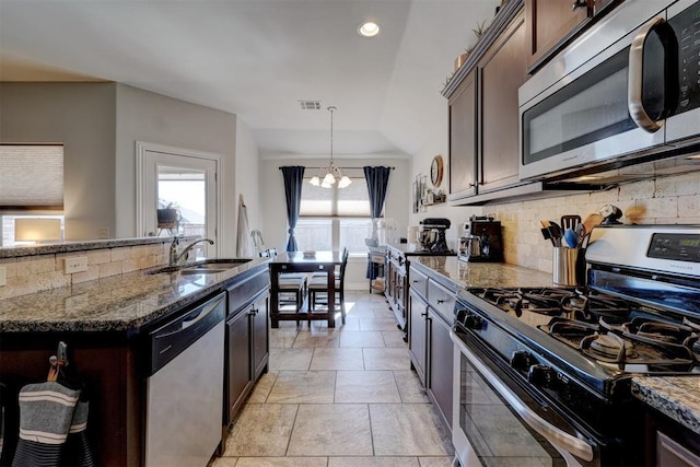 kitchen featuring dark stone countertops, visible vents, a sink, stainless steel appliances, and tasteful backsplash