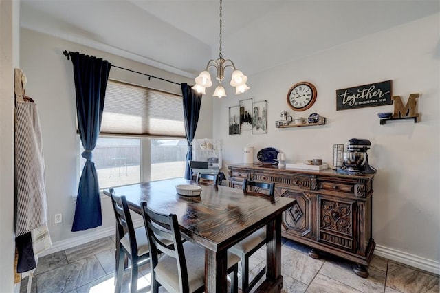 dining space featuring baseboards and a chandelier