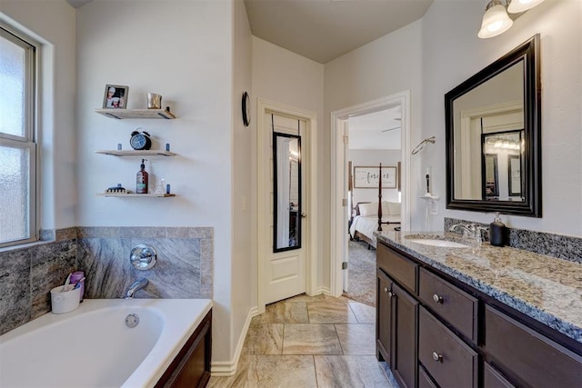 full bathroom with a bath, connected bathroom, vanity, and baseboards