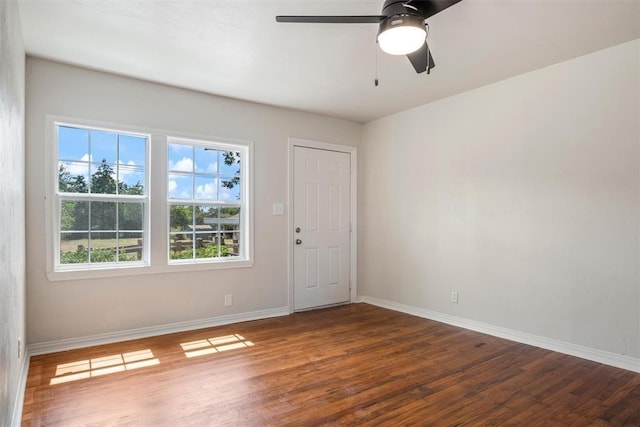 empty room with a ceiling fan, wood finished floors, and baseboards