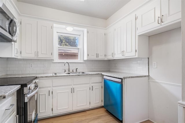 kitchen with a sink, stainless steel appliances, and white cabinetry