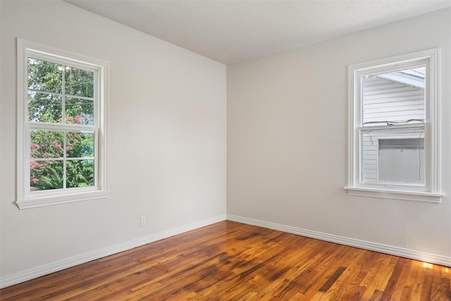 empty room featuring baseboards and wood finished floors