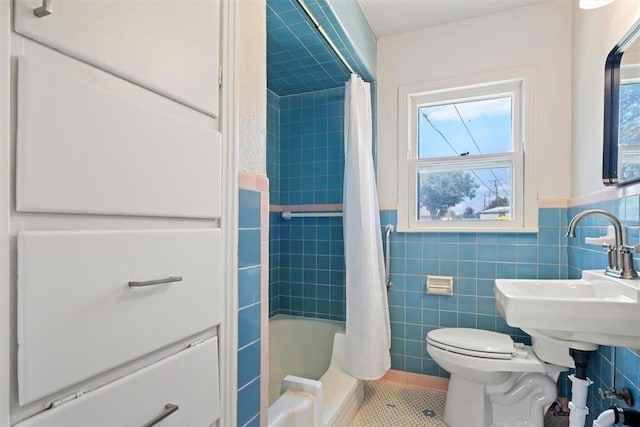 full bathroom featuring toilet, tile walls, plenty of natural light, and wainscoting