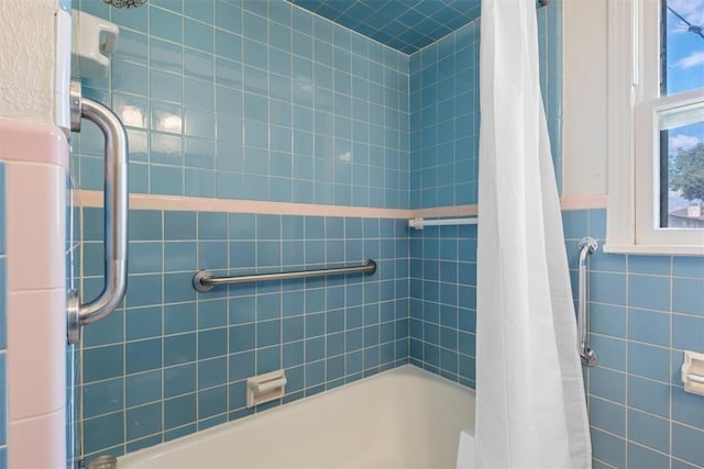 full bathroom featuring shower / bath combo with shower curtain and tile walls