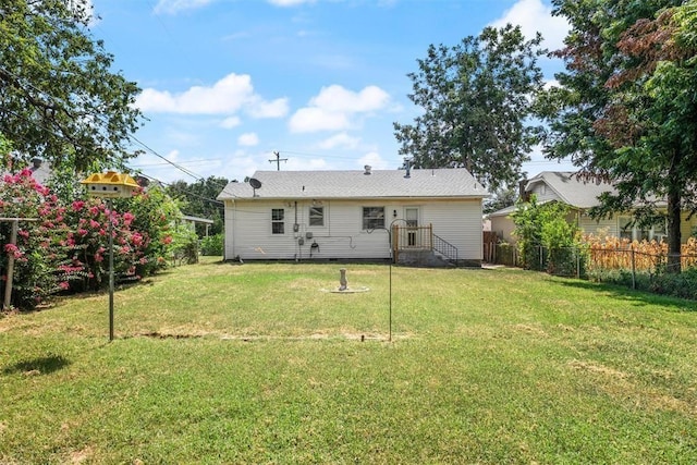 back of property featuring fence, a lawn, and crawl space