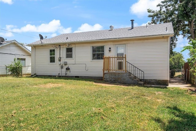 rear view of house with crawl space, a lawn, a shingled roof, and fence