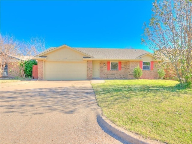 single story home featuring a garage, brick siding, concrete driveway, and a front yard