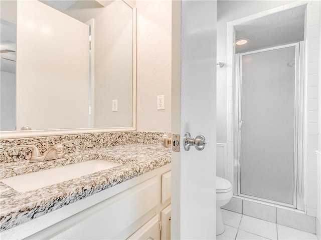 full bath with tile patterned flooring, a shower stall, toilet, and vanity