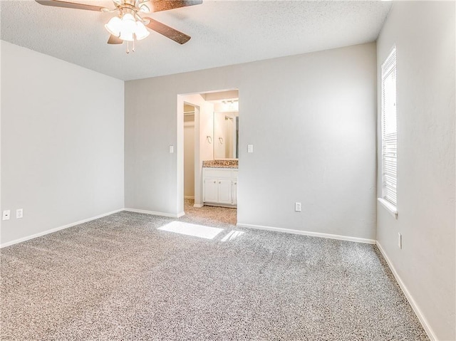 unfurnished bedroom with a ceiling fan, light colored carpet, a textured ceiling, and baseboards