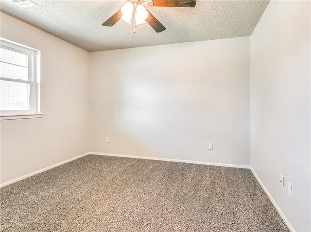 empty room with a textured ceiling, carpet flooring, and baseboards