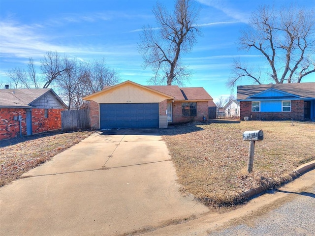 view of front of house with a garage, fence, brick siding, and driveway