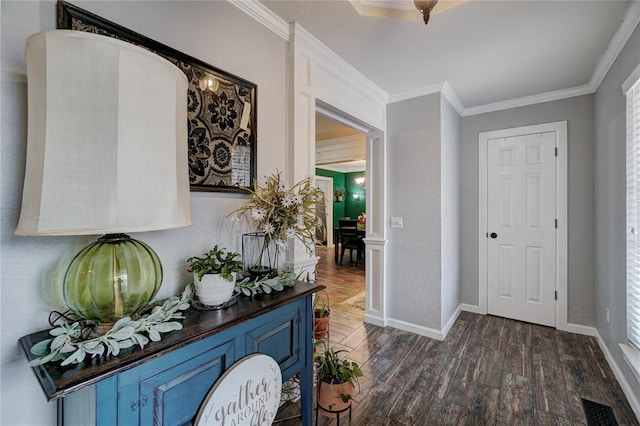 entrance foyer featuring visible vents, baseboards, ornamental molding, and dark wood finished floors