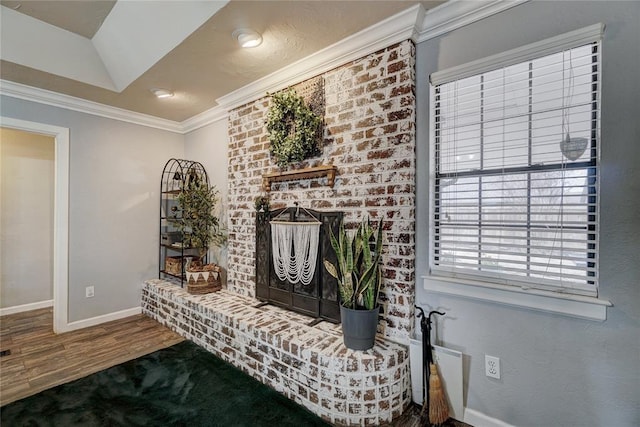 living area featuring baseboards, wood finished floors, and crown molding