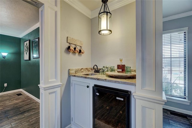 bar featuring ornamental molding, a sink, dark wood-style floors, wine cooler, and wet bar