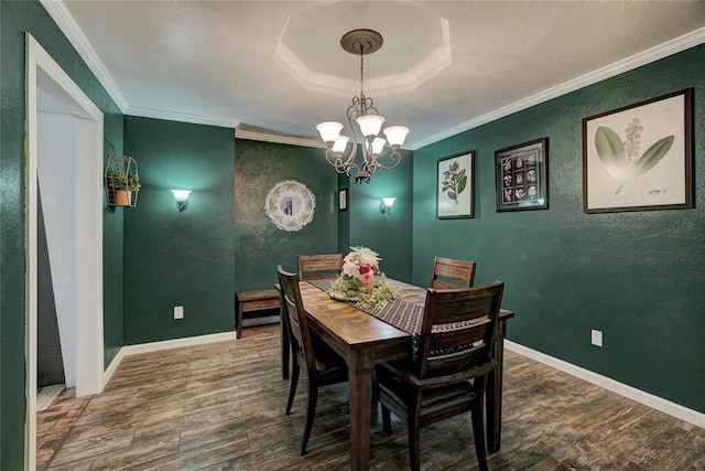 dining room featuring ornamental molding, wood finished floors, baseboards, and a chandelier