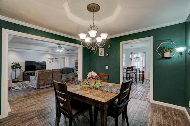 dining area with baseboards, dark wood-style flooring, crown molding, a textured wall, and a raised ceiling