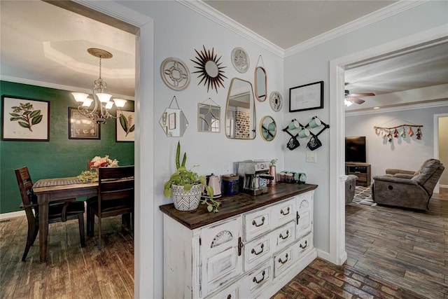 corridor featuring crown molding, baseboards, dark wood-type flooring, and a chandelier