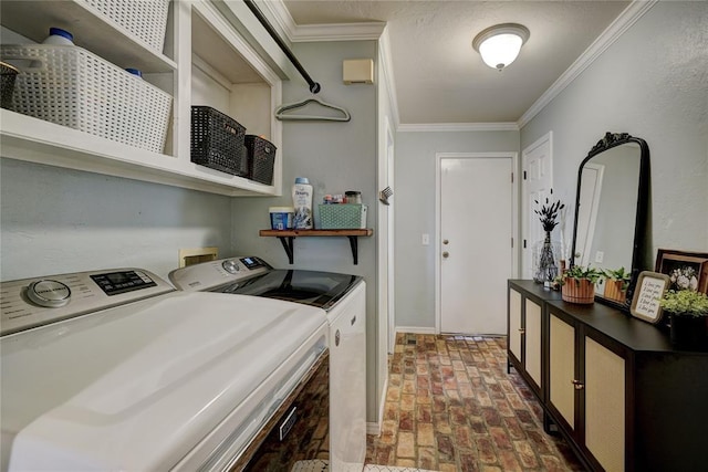 clothes washing area featuring brick floor, ornamental molding, laundry area, and washer and clothes dryer