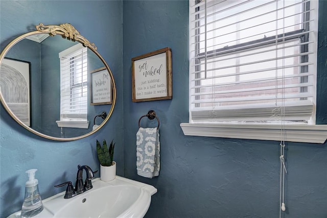 bathroom with a textured wall and a sink