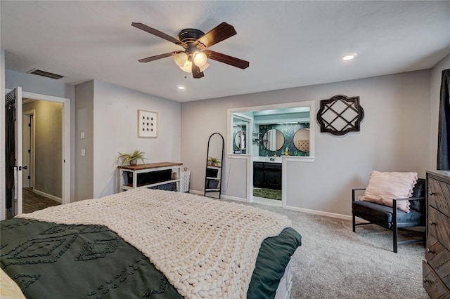 bedroom with visible vents, baseboards, carpet floors, ensuite bath, and a ceiling fan