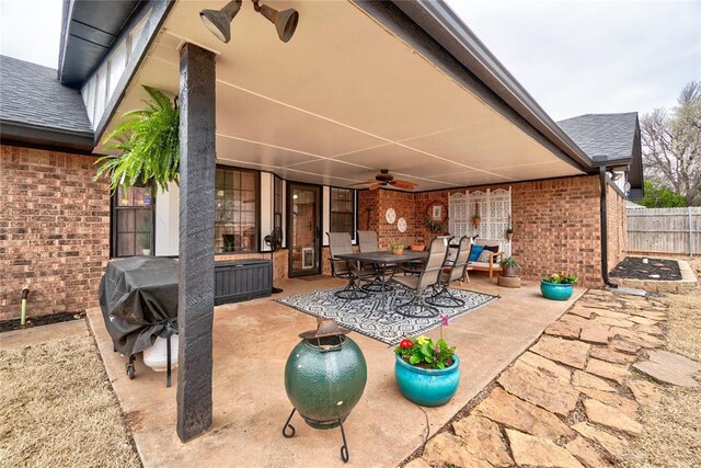 view of patio with outdoor dining space, a ceiling fan, and fence