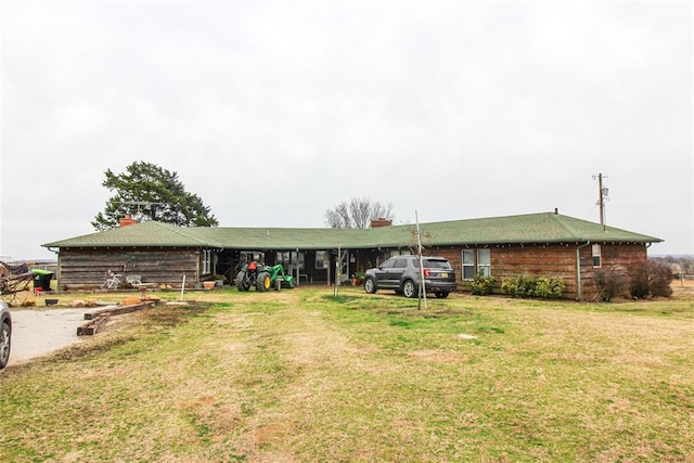 view of front of home with a front yard and a carport